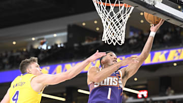 Oct 3, 2025; Palm Desert, California, USA; Phoenix Suns guard Devin Booker (1) shoots past Los Angeles Lakers guard Dalton Knecht (4) at Acrisure Arena. Mandatory Credit: Denis Poroy-Imagn Images