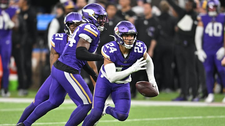 Oct 23, 2023; Minneapolis, Minnesota, USA; Minnesota Vikings safety Camryn Bynum (24) makes an interception during the fourth quarter as safety Josh Metellus (44) and cornerback Akayleb Evans (21) looks on against the San Francisco 49ers at U.S. Bank Stadium. Mandatory Credit: Jeffrey Becker-Imagn Images