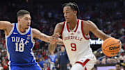 Dec 8, 2024; Louisville, Kentucky, USA;  Louisville Cardinals forward Khani Rooths (9) dribbles against Duke Blue Devils forward Mason Gillis (18) during the second half at KFC Yum! Center. Duke defeated Louisville 76-65. Mandatory Credit: Jamie Rhodes-Imagn Images