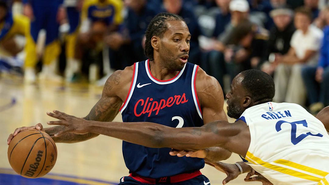 Apr 13, 2025; San Francisco, California, USA; Golden State Warriors forward Draymond Green (23) extends for the ball against LA Clippers forward Kawhi Leonard (2) during the third quarter at Chase Center. Mandatory Credit: Robert Edwards-Imagn Images