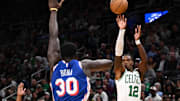 Oct 12, 2024; Boston, Massachusetts, USA; Boston Celtics guard Lonnie Walker IV (12) attempts a basket against Philadelphia 76ers center Adem Bona (30) during the second half at the TD Garden. Mandatory Credit: Brian Fluharty-Imagn Images