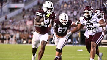 Aug 31, 2024; Starkville, Mississippi, USA; Mississippi State Bulldogs running back Davon Booth (21) runs the ball while defended by Eastern Kentucky Colonels defensive lineman Ryan Jackson (97) during the third quarter at Davis Wade Stadium at Scott Field. Mandatory Credit: Matt Bush-Imagn Images