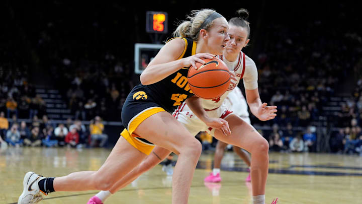 Iowa guard Kylie Feuerbach (4) drives to the basket against Wisconsin guard Lily Krahn (4) during a Big Ten conference game Sunday, March 2, 2025 at Carver-Hawkeye Arena in Iowa City, Iowa.