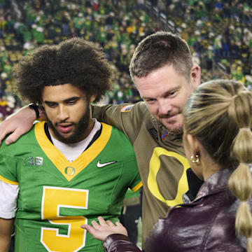 Nov 14, 2025; Eugene, Oregon, USA; Oregon Ducks quarterback Dante Moore (5) and head coach Dan Lanning talk to a reporter after a game against the Minnesota Golden Gophers at Autzen Stadium. Mandatory Credit: Troy Wayrynen-Imagn Images