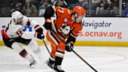 Dec 1, 2024; Anaheim, California, USA;  Anaheim Ducks right wing Frank Vatrano (77) controls the puck with pressure from Ottawa Senators defenseman Travis Hamonic (23) during the second period at Honda Center. Mandatory Credit: Alex Gallardo-Imagn Images