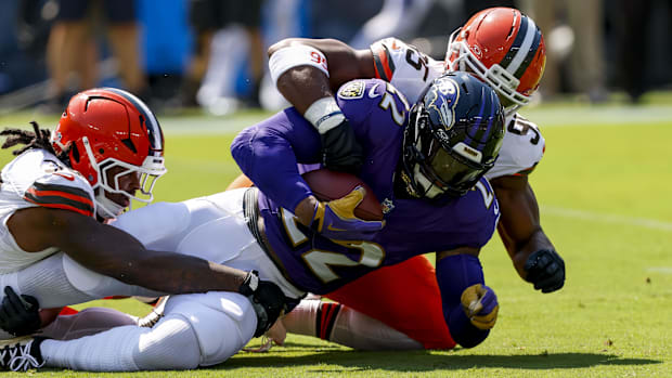 Baltimore Ravens running back Derrick Henry (22) is tackled by Cleveland Browns defensive end Myles Garrett (95).