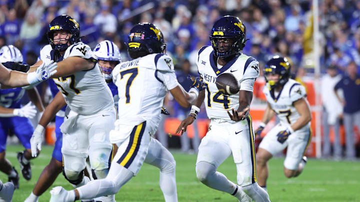 Oct 3, 2025; Provo, Utah, USA; West Virginia Mountaineers quarterback Khalil Wilkins (14) pitches the ball to wide receiver Jarod Bowie (7) during the second quarter of the game against the Brigham Young Cougars at LaVell Edwards Stadium. Mandatory Credit: Rob Gray-Imagn Images