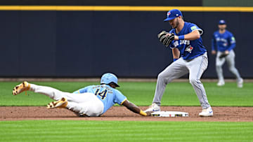 Jun 11, 2024; Milwaukee, Wisconsin, USA; Milwaukee Brewers second base Andruw Monasterio (14) dives safely back to second base ahead of the tag by Toronto Blue Jays outfielder Daulton Varsho (25) in the first inning at American Family Field. Mandatory Credit: Michael McLoone-Imagn Images