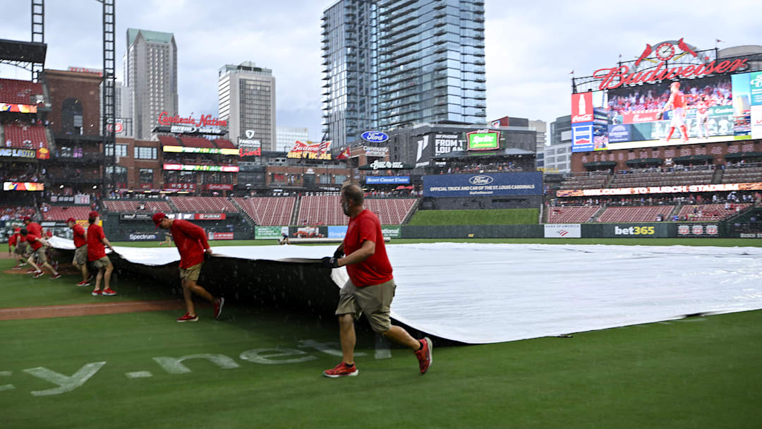 Jul 13, 2025; St. Louis, Missouri, USA;  St. Louis Cardinals grounds crew pulls the tarp on the field during a rain delay in the third inning of a game between the St. Louis Cardinals and the Atlanta Braves at Busch Stadium. Mandatory Credit: Jeff Curry-Imagn Images