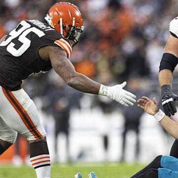 Dec 10, 2023; Cleveland, Ohio, USA; Cleveland Browns defensive end Myles Garrett (95) lends a hand to help up Jacksonville Jaguars quarterback Trevor Lawrence (16) during the fourth quarter at Cleveland Browns Stadium. Mandatory Credit: Scott Galvin-Imagn Images