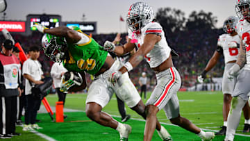 Jan 1, 2025; Pasadena, CA, USA;  Ohio State Buckeyes cornerback Davison Igbinosun (1) pushes Oregon Ducks running back Noah Whittington (6) out of bounds in the second half in the 2025 Rose Bowl college football quarterfinal game at Rose Bowl Stadium. Mandatory Credit: Gary A. Vasquez-Imagn Images