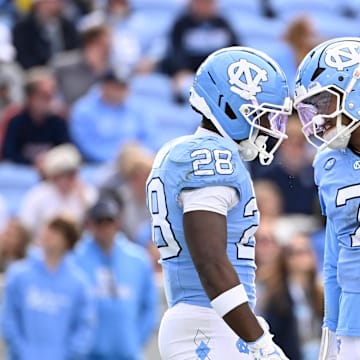 Oct 25, 2025; Chapel Hill, North Carolina, USA; North Carolina Tar Heels running back Benjamin Hall (28) with quarterback Gio Lopez (7) on the field in the third quarter at Kenan Stadium. 