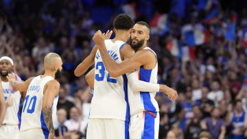 Jul 27, 2024; Villeneuve-d'Ascq, France; France power forward Victor Wembanyama (32) embraces centre Rudy Gobert (27) after the game against Brazil during the Paris 2024 Olympic Summer Games at Stade Pierre-Mauroy. Mandatory Credit: John David Mercer-USA TODAY Sports