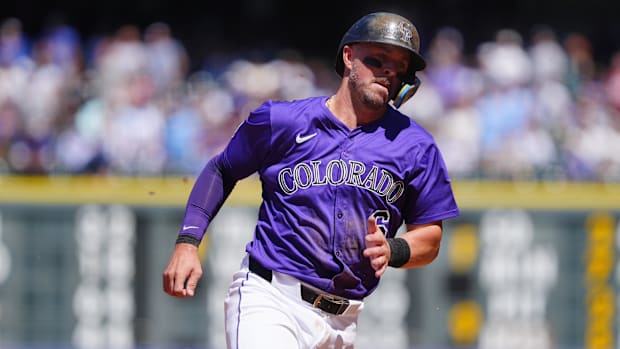 Kyle Farmer running for the Colorado Rockies wearing Purple jersey and white pants. 