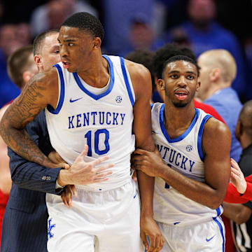Dec 14, 2024; Lexington, Kentucky, USA; Kentucky Wildcats guard Lamont Butler (1) pushes Kentucky Wildcats forward Brandon Garrison (10) out of the Louisville Cardinals bench area after the teams get together on the sideline during the second half at Rupp Arena at Central Bank Center. Mandatory Credit: Jordan Prather-Imagn Images