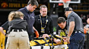 Iowa cheerleader Austin Beam is attended to by team trainers and paramedics after being injured during the game between Iowa and Minnesota at Carver-Hawkeye Arena in Iowa City, Iowa, on Jan. 21, 2025. Beam fell while performing during a time out. 