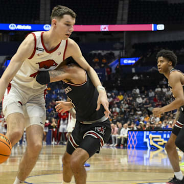 Mar 12, 2025; Nashville, TN, USA;  Arkansas Razorbacks forward Zvonimir Ivisic (44) goes around South Carolina Gamecocks guard Jacobi Wright (1) during the first half at Bridgestone Arena. Mandatory Credit: Steve Roberts-Imagn Images