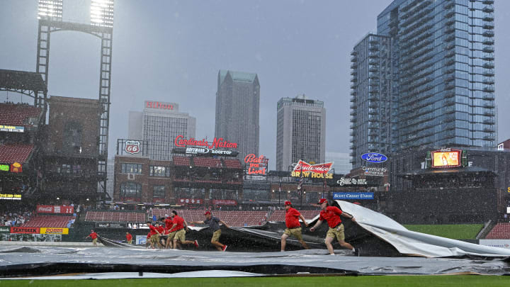 May 4, 2024; St. Louis, Missouri, USA;  St. Louis Cardinals grounds crew pulls the tarp on the field as heavy rain falls during the tenth inning of a game against the Chicago White Sox at Busch Stadium. Mandatory Credit: Jeff Curry-USA TODAY Sports