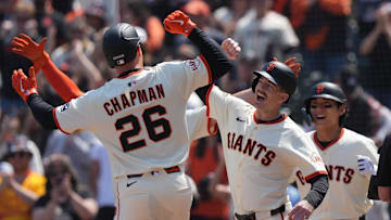 May 3, 2025; San Francisco, California, USA; San Francisco Giants third baseman Matt Chapman (26) is congratulated by right fielder Mike Yastrzemski (center right) after hitting a grand slam home run against the Colorado Rockies during the sixth inning at Oracle Park. Mandatory Credit: Darren Yamashita-Imagn Images