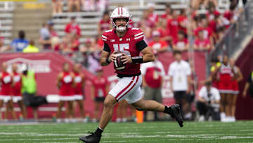 Sep 20, 2025; Madison, Wisconsin, USA;  Wisconsin Badgers quarterback Hunter Simmons (15) rolls out of the pocket during the fourth quarter against the Maryland Terrapins at Camp Randall Stadium. Mandatory Credit: Jeff Hanisch-Imagn Images