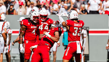 Oct 4, 2025; Raleigh, North Carolina, USA;  NC State Wolfpack defensive end Sabastian Harsh (54) and linebacker Jr. Kenny Soares (33) celebrate a tackle during the first half of the game against Campbell Fighting Camels at Carter-Finley Stadium. Mandatory Credit: Jaylynn Nash-Imagn Images