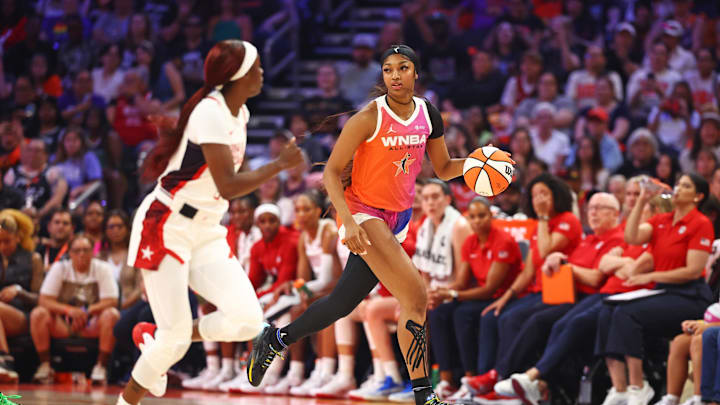Jul 20, 2024; Phoenix, AZ, USA; Team WNBA forward Angel Reese (5) drives to the basket during the first half as USA Women's National Team guard Kahleah Copper (7) defends at Footprint Center. Mandatory Credit: Mark J. Rebilas-Imagn Images