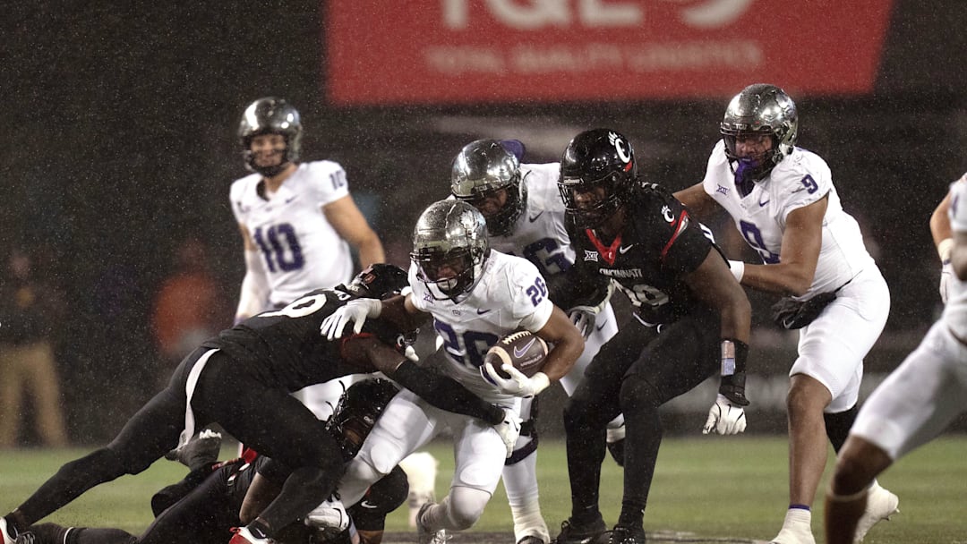 Nov 30, 2024; Cincinnati, Ohio, USA; TCU Horned Frogs running back Jeremy Payne (26) is tackled by Cincinnati Bearcats linebacker Jiquan Sanks (9) in the third quarter at Nippert Stadium. Mandatory Credit: Albert Cesare/USA TODAY Network via Imagn Images