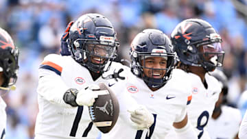 Oct 25, 2025; Chapel Hill, North Carolina, USA; Virginia Cavaliers defensive end Mitchell Melton (17) celebrates with linebacker Maddox Marcellus (11) after intercepting the ball in the third quarter at Kenan Stadium. Mandatory Credit: Bob Donnan-Imagn Images