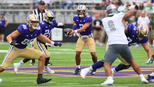 Huskies quarterback Demond Williams Jr. (2) hands the ball to running back Adam Mohammed (24) during the second half against 