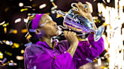 Coco Gauff kisses the WTA Finals trophy.