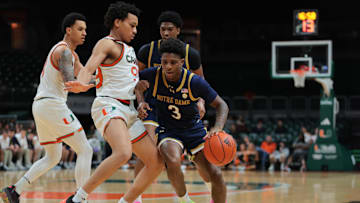 Feb 1, 2025; Coral Gables, Florida, USA; Notre Dame Fighting Irish guard Markus Burton (3) drives to the basket against Miami Hurricanes guard Divine Ugochukwu (99) during the first half at Watsco Center. Mandatory Credit: Sam Navarro-Imagn Images