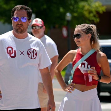 A fan wearing an SEC shirt watches as members of the OU band and the spirit squad perform at Campus Corner during a celebration for OU joining the Southeastern Conference in Norman, Okla., Monday, July 1, 2024.