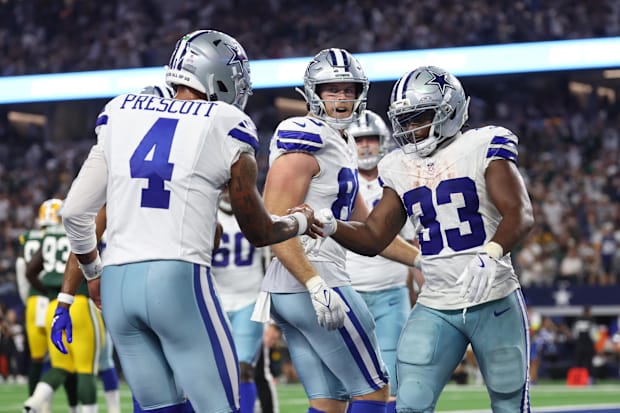 Dallas Cowboys RB Javonte Williams celebrates with QB Dak Prescott after scoring a touchdown against the Green Bay Packers. 