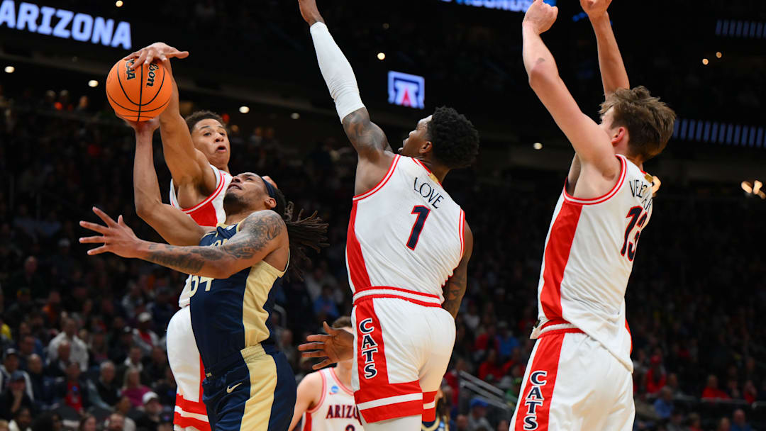 Mar 21, 2025; Seattle, WA, USA; Arizona Wildcats forward Carter Bryant (9) fouls Akron Zips guard Nate Johnson (34) during the second half in the first round of the NCAA Tournament at Climate Pledge Arena. Mandatory Credit: Steven Bisig-Imagn Images
