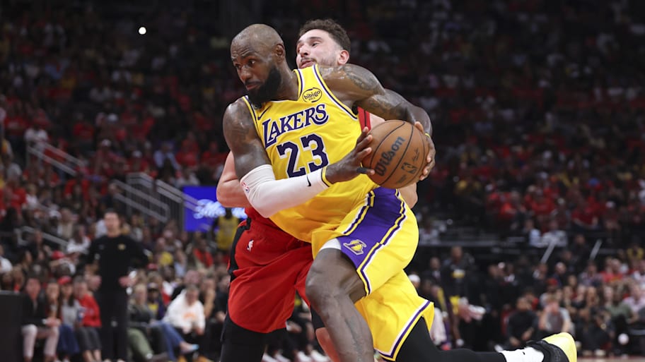 Los Angeles Lakers forward LeBron James drives with the ball as Houston Rockets center Alperen Şengün defends.