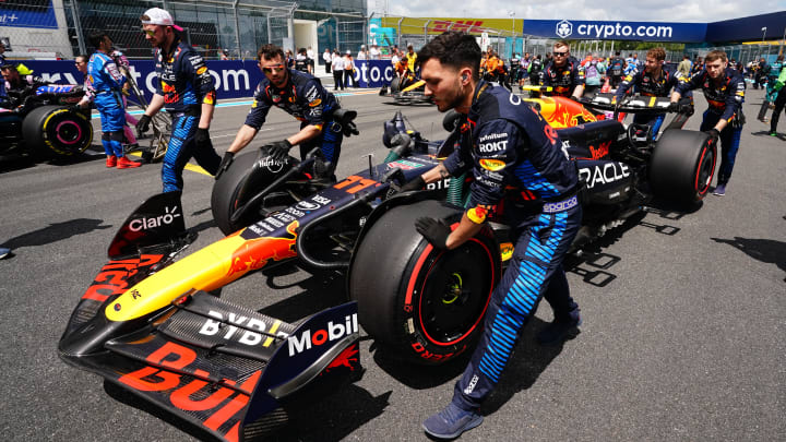 May 4, 2024; Miami Gardens, Florida, USA; Crewmembers push the car of Red Bull Racing driver Sergio Perez (11) on the grid before the F1 Sprint Race at Miami International Autodrome. Mandatory Credit: John David Mercer-USA TODAY Sports