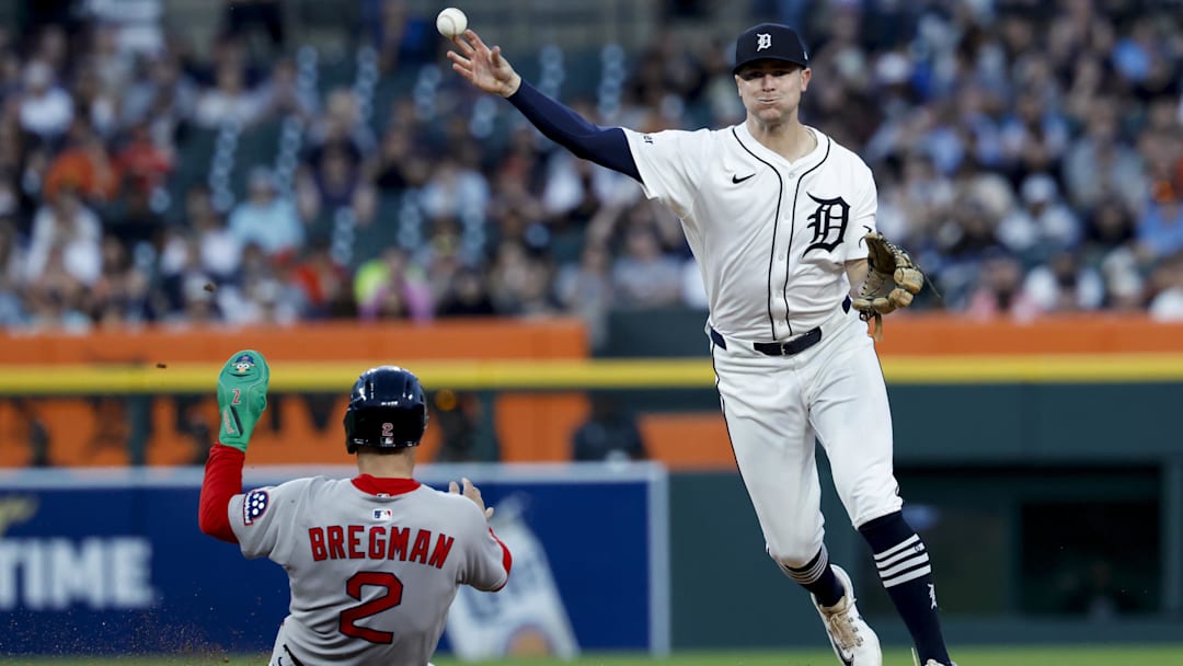  Detroit Tigers shortstop Trey Sweeney (27) makes a throw to first to complete a double play as Boston Red Sox third baseman Alex Bregman (2) slides into second in the seventh inning at Comerica Park.