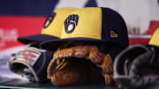 Aug 4, 2025; Atlanta, Georgia, USA; A detailed view of a Milwaukee Brewers hat and glove in the dugout against the Atlanta Braves in the fourth inning at Truist Park. Mandatory Credit: Brett Davis-Imagn Images
