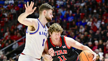 Feb 15, 2025; Salt Lake City, Utah, USA; Utah Utes forward Caleb Lohner (11) drives into Kansas Jayhawks center Hunter Dickinson (1) during the second half at the Jon M. Huntsman Center. Mandatory Credit: Christopher Creveling-Imagn Images