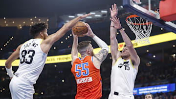 Dec 3, 2024; Oklahoma City, Oklahoma, USA; Oklahoma City Thunder center Isaiah Hartenstein (55) goes to the basket between Utah Jazz guard Johnny Juzang (33) and forward Drew Eubanks (15) during the second quarter of an NBA Cup game at Paycom Center. Mandatory Credit: Alonzo Adams-Imagn Images