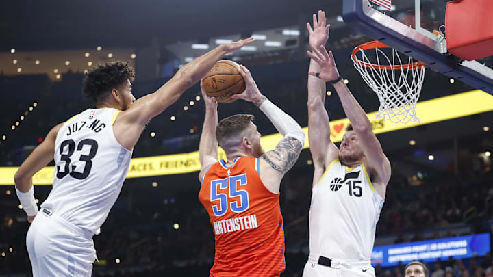 Dec 3, 2024; Oklahoma City, Oklahoma, USA; Oklahoma City Thunder center Isaiah Hartenstein (55) goes to the basket between Utah Jazz guard Johnny Juzang (33) and forward Drew Eubanks (15) during the second quarter of an NBA Cup game at Paycom Center. Mandatory Credit: Alonzo Adams-Imagn Images