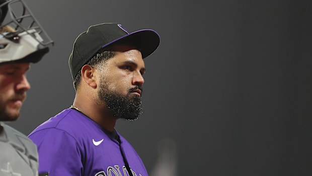 Colorado Rockies pitcher German Marquez looks into the crowd wearing a purple jersey and black and purple hat.
