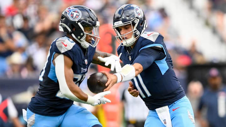 Nov 3, 2024; Nashville, Tennessee, USA;  Tennessee Titans quarterback Mason Rudolph (11) hands the ball off to running back Tony Pollard (20) against the New England Patriots during the first half at Nissan Stadium. Mandatory Credit: Steve Roberts-Imagn Images