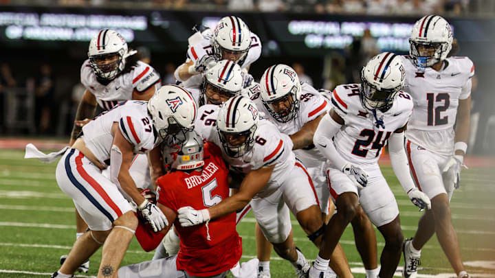 Aug 31, 2024; Tucson, Arizona, USA; Arizona Wildcats defensive back Owen Goss (27), Arizona Wildcats linebacker Taye Brown (6), Arizona Wildcats defensive back (13) and Arizona Wildcats defensive lineman Cyrus Durham (99) all tackle New Mexico Lobos tight end Trace Bruckler (5) on final play at the end of the fourth quarter at Arizona Stadium. 