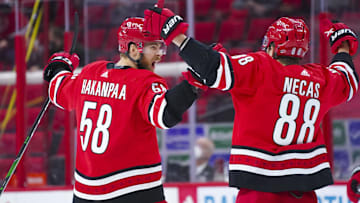 Apr 17, 2021; Raleigh, North Carolina, USA; Carolina Hurricanes defenseman Jani Hakanpaa (58) celebrates his third period goal with center Martin Necas (88) against the Nashville Predators at PNC Arena. Mandatory Credit: James Guillory-Imagn Images