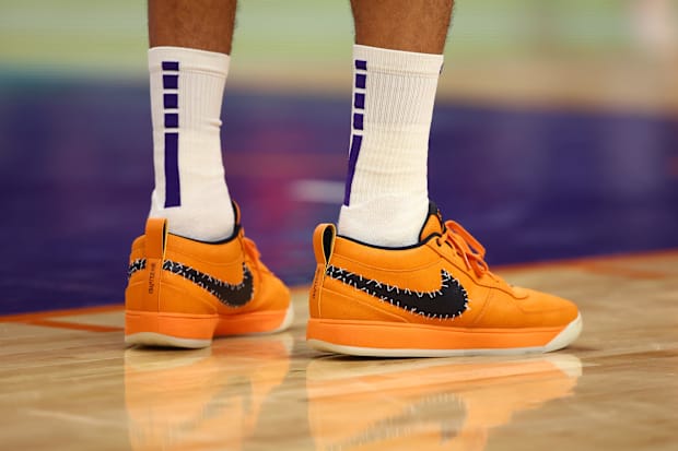 Phoenix Suns guard Devin Booker's orange and black Nike sneakers.