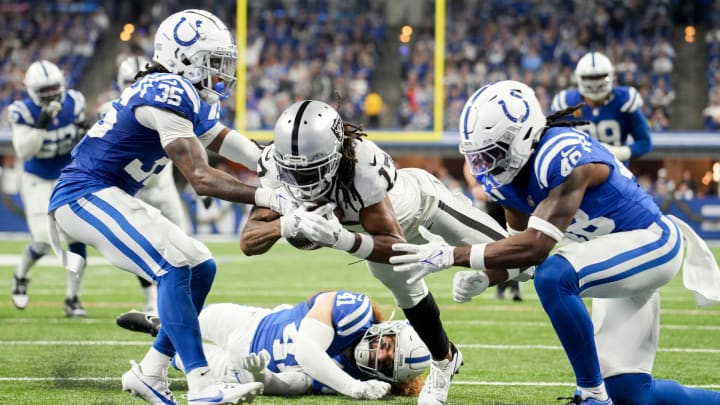 Las Vegas Raiders wide receiver Davante Adams (17) comes up short as he dives toward the end zone between Indianapolis Colts cornerback Chris Lammons (35) and Indianapolis Colts safety Ronnie Harrison Jr. (48) on Sunday, Dec. 31, 2023, during a game against the Las Vegas Raiders at Lucas Oil Stadium in Indianapolis.