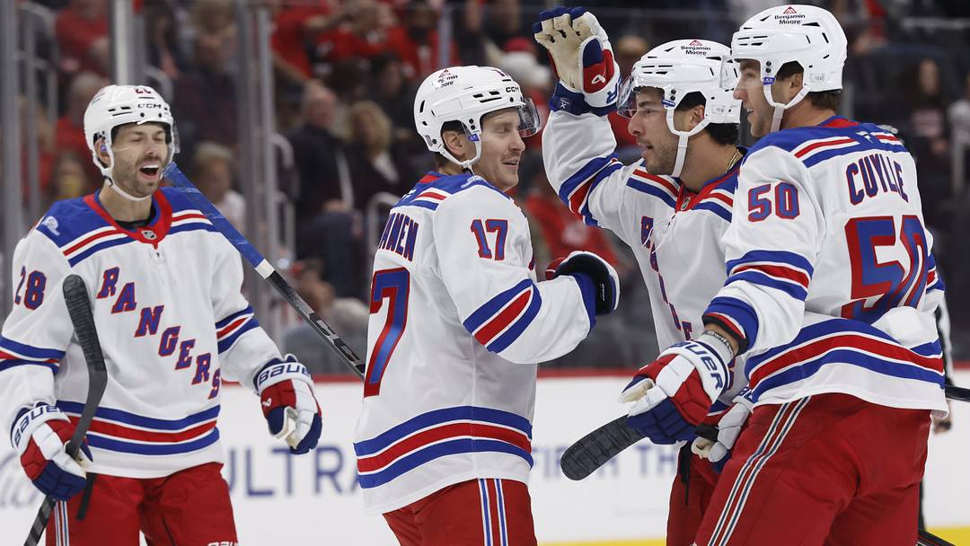 Oct 2, 2026; Detroit, Michigan, USA;  New York Rangers defenseman Sean Durzi (5) receives congratulations from teammates after scoring in the first period against the Detroit Red Wings at Little Caesars Arena.  Mandatory Credit: Rick Osentoski-Imagn Images