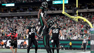 Oct 31, 2024; East Rutherford, New Jersey, USA; New York Jets wide receiver Davante Adams (17) celebrates his touchdown against the Houston Texans with offensive tackles Olu Fashanu (74) and Max Mitchell (61) and center Joe Tippmann (66) during the fourth quarter at MetLife Stadium. 