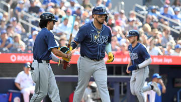 Jul 25, 2024; Toronto, Ontario, CAN; Tampa Bay Rays first baseman Isaac Paredes (17) leaves the batters box after drawing a bases loaded walk as shortstop Taylor Walls (8) comes in to score against the Toronto Blue Jays in the seventh inning at Rogers Centre. Mandatory Credit: Dan Hamilton-USA TODAY Sports